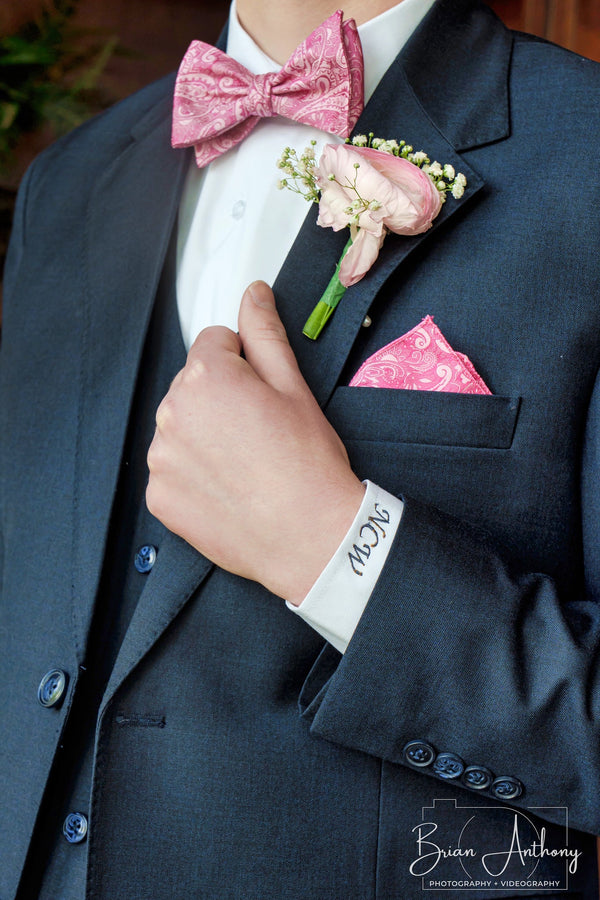 The details: monogrammed cuff, pink bow tie