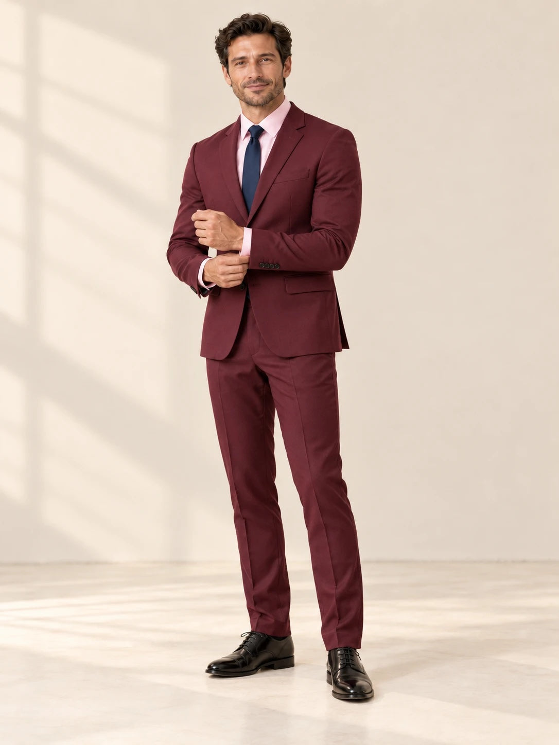 Burgundy suit styled with a light pink shirt and navy tie