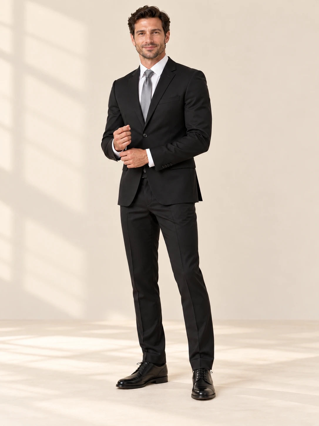Black suit styled with a white shirt and silver tie