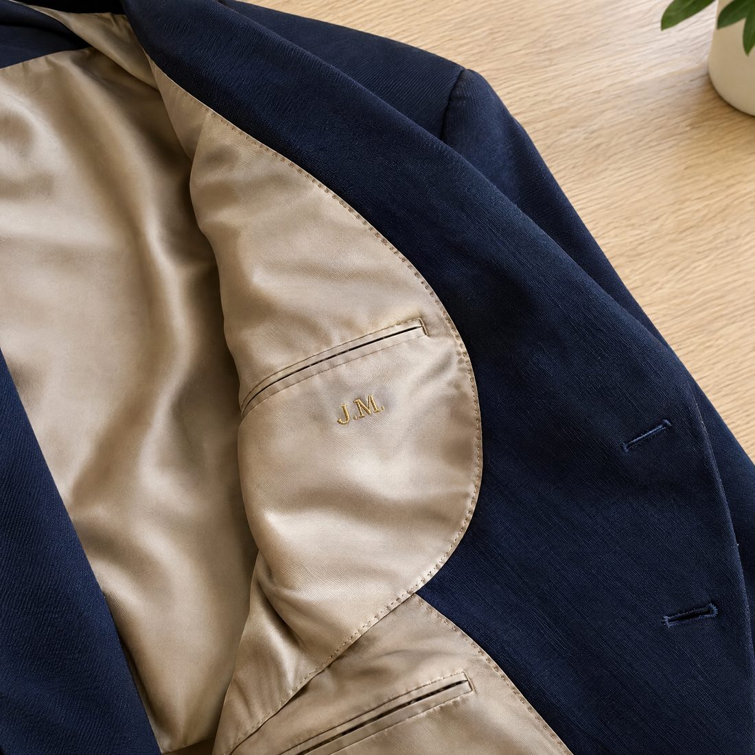 Gold embroidered initials inside a navy suit jacket